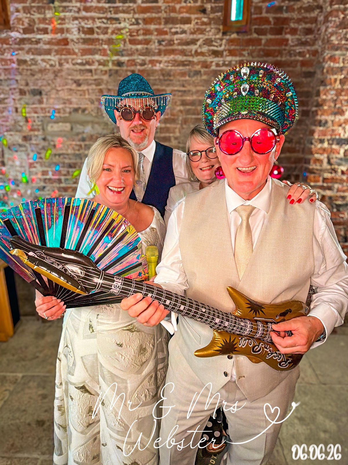 Wedding guests in sequinned hats and statement glasses with an inflatable guitar and fan at a hosted 360 photo booth, Yorkshire