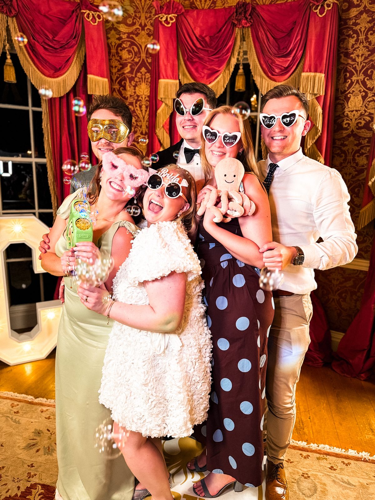 Wedding guests with premium props at a hosted 360 photo booth, Yorkshire